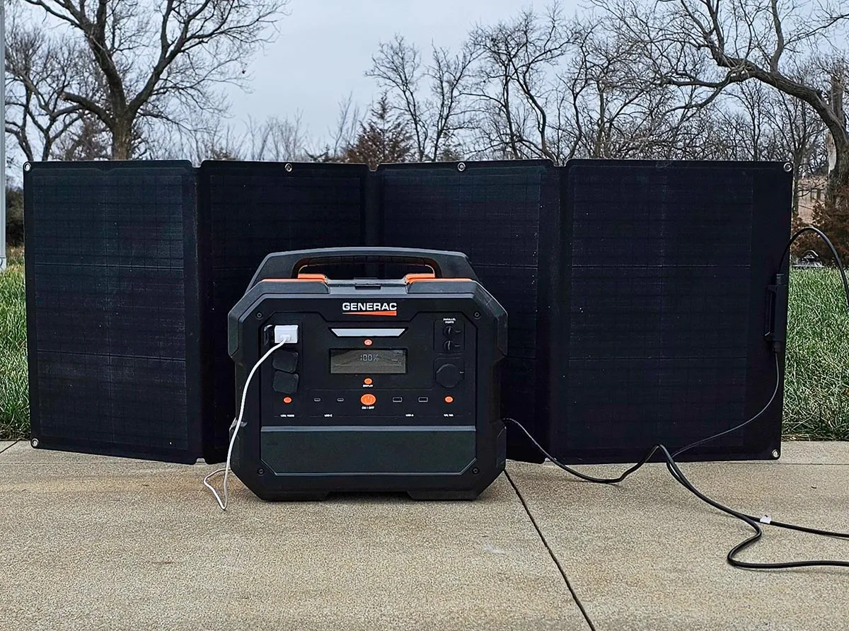 The Generac GB2000 Portable Power Station, встановлений на вулиці під час тестування з сонячною панеллю позаду нього.
